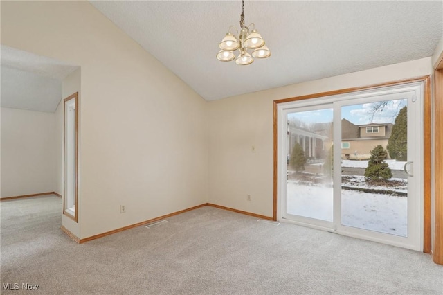 empty room featuring lofted ceiling, baseboards, a chandelier, and light carpet