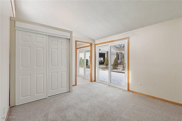 unfurnished bedroom featuring visible vents, baseboards, carpet flooring, a textured ceiling, and access to outside