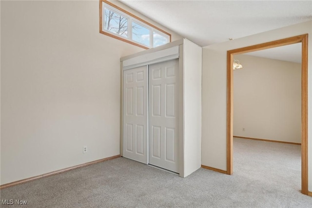 unfurnished bedroom featuring a closet, baseboards, and carpet