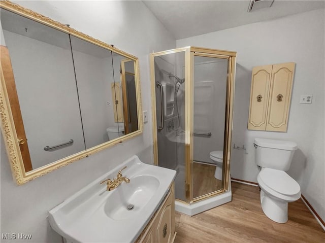 bathroom featuring a shower stall, toilet, wood finished floors, and visible vents