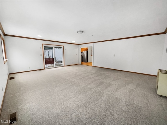 unfurnished living room with crown molding, baseboards, visible vents, and light carpet