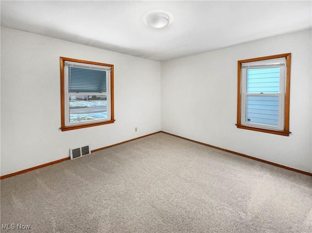 spare room with visible vents, baseboards, and carpet