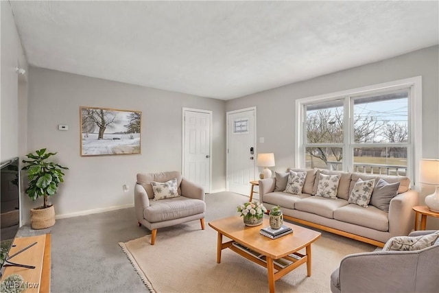 living room featuring baseboards and light colored carpet