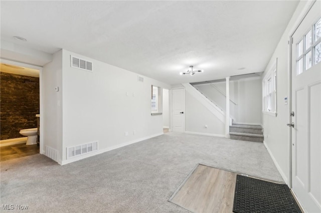 interior space featuring visible vents, carpet floors, and stairway