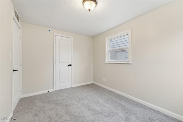 unfurnished bedroom with visible vents, baseboards, and carpet flooring