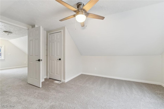 bonus room with baseboards, carpet, lofted ceiling, and a textured ceiling