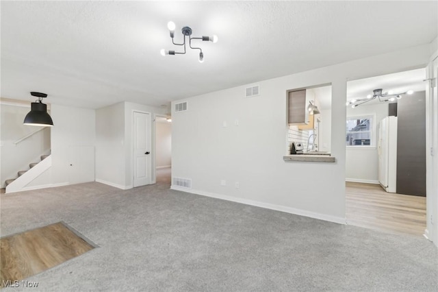 unfurnished living room with visible vents and carpet