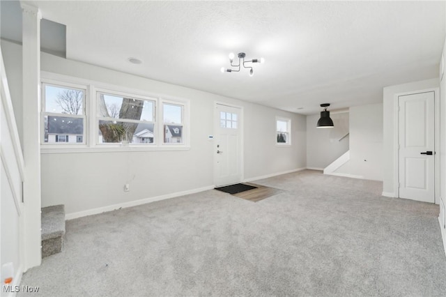 entrance foyer featuring stairway, carpet, and baseboards