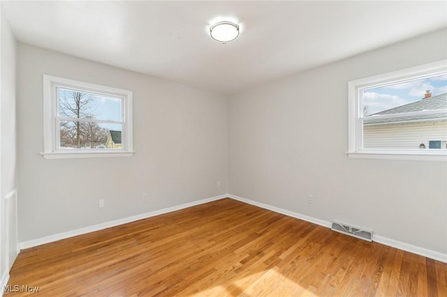 spare room featuring visible vents, baseboards, and light wood-style flooring