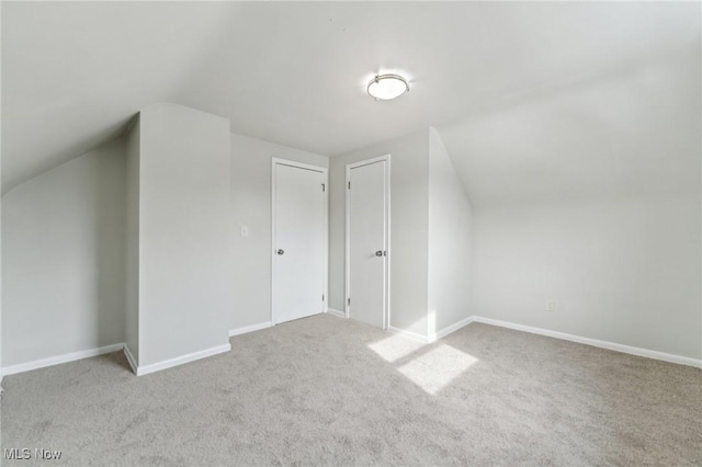 bonus room featuring baseboards, lofted ceiling, and carpet flooring