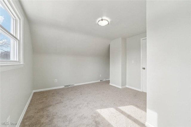 additional living space with lofted ceiling, carpet, visible vents, and baseboards