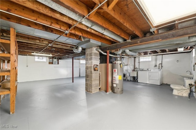 below grade area featuring gas water heater, washer and dryer, and a sink