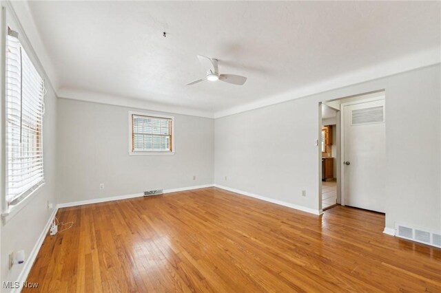 empty room featuring visible vents, baseboards, light wood-style floors, and ceiling fan