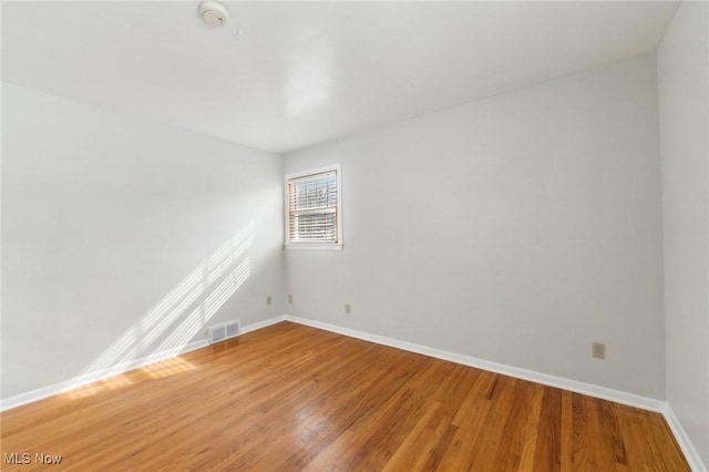 unfurnished room featuring visible vents, baseboards, and light wood-style flooring