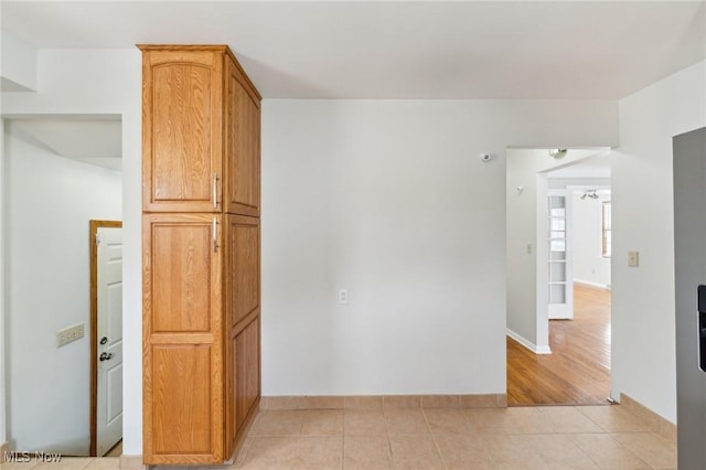 empty room with baseboards and light tile patterned flooring