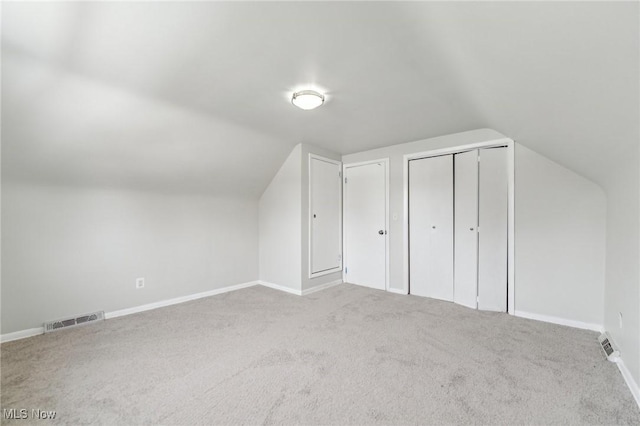 bonus room featuring lofted ceiling, carpet flooring, baseboards, and visible vents