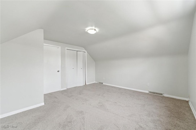 bonus room with vaulted ceiling, carpet flooring, baseboards, and visible vents