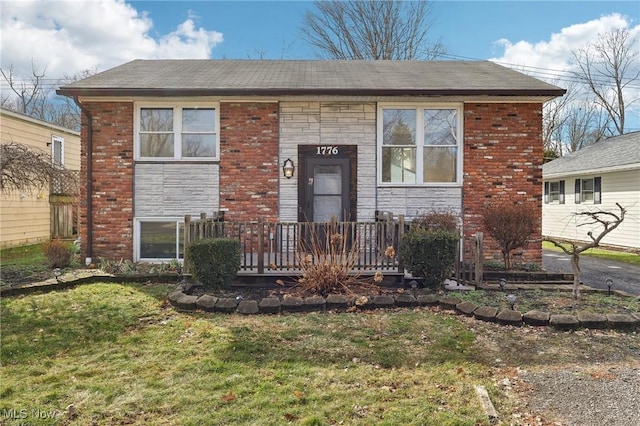 view of front facade featuring brick siding, stone siding, and a front yard