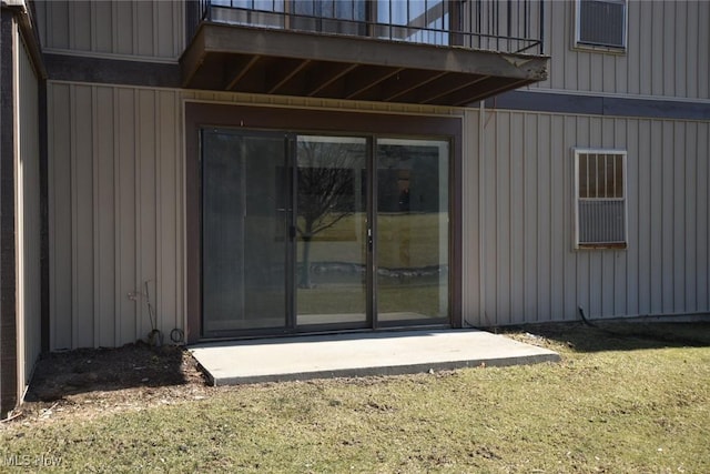 view of exterior entry featuring a balcony and board and batten siding