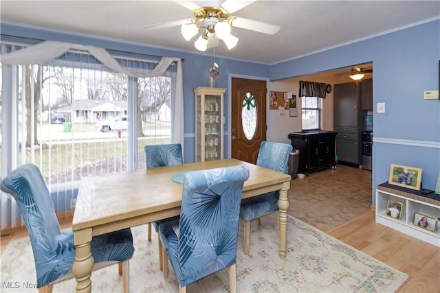 dining area featuring crown molding, wood finished floors, and ceiling fan