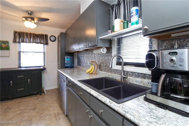 kitchen with tasteful backsplash, a sink, light countertops, a ceiling fan, and stainless steel dishwasher