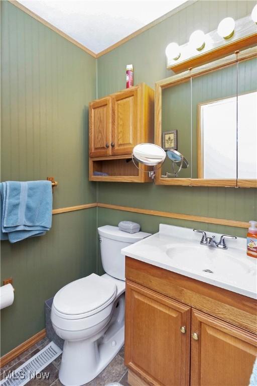 bathroom with vanity, toilet, and crown molding