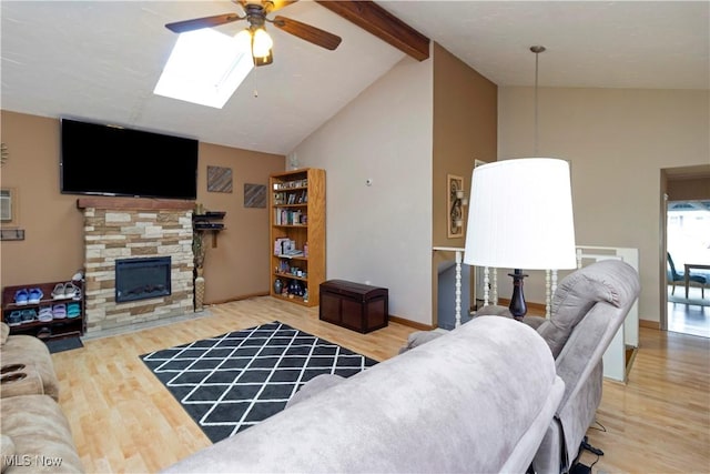 living area featuring beamed ceiling, high vaulted ceiling, wood finished floors, and a fireplace