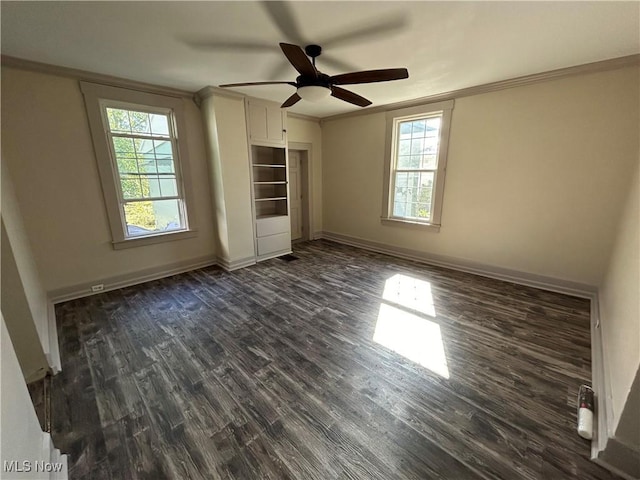 unfurnished bedroom featuring dark wood finished floors, multiple windows, baseboards, and ornamental molding