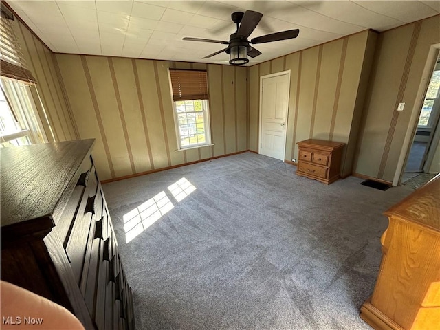 unfurnished bedroom featuring a ceiling fan and carpet