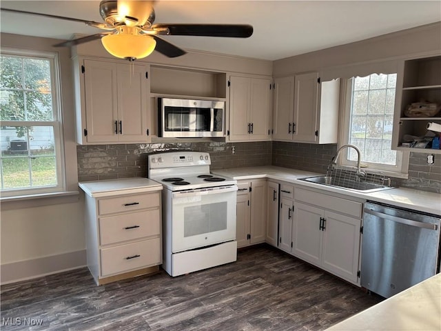 kitchen featuring a sink, dark wood-type flooring, light countertops, appliances with stainless steel finishes, and white cabinetry