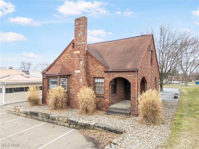 537 Main St, Navarre, OH 44662 - english style home featuring uncovered parking, brick siding, roof with shingles, and a chimney