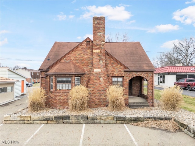 537 Main St, Navarre, OH 44662 - view of front of property featuring brick siding, uncovered parking, a chimney, and roof with shingles