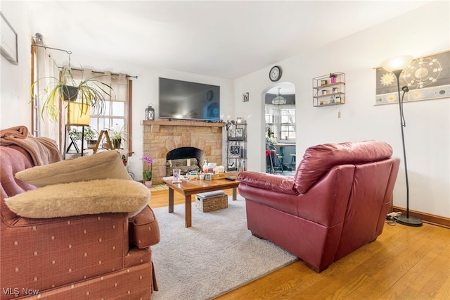 537 Main St, Navarre, OH 44662 - living room featuring a stone fireplace, wood finished floors, and baseboards