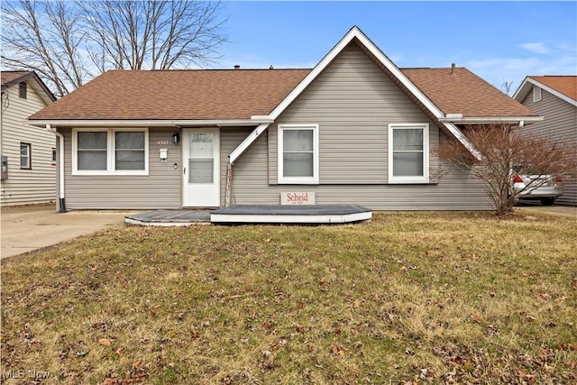 view of front of property with a front yard and roof with shingles