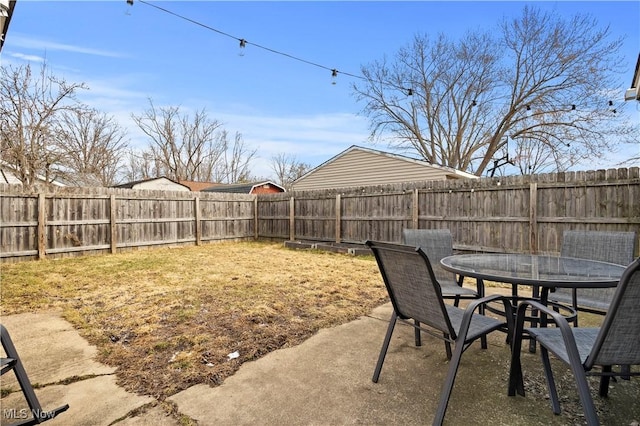 view of yard featuring a patio area, outdoor dining space, and a fenced backyard