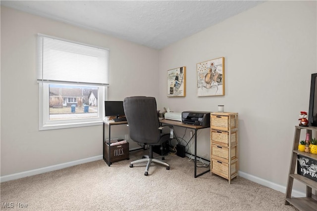 carpeted home office featuring a textured ceiling and baseboards