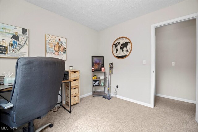 office space featuring baseboards, light carpet, and a textured ceiling