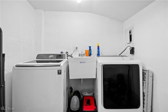 washroom with laundry area, washing machine and dryer, and a sink