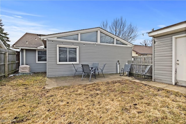 rear view of house featuring fence and a patio area