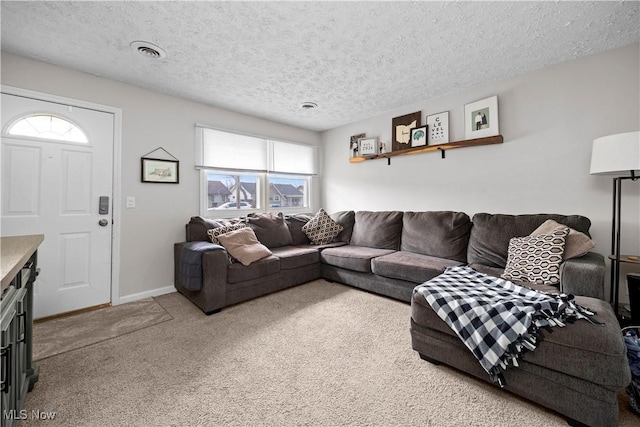 living room featuring visible vents, a textured ceiling, baseboards, and carpet floors