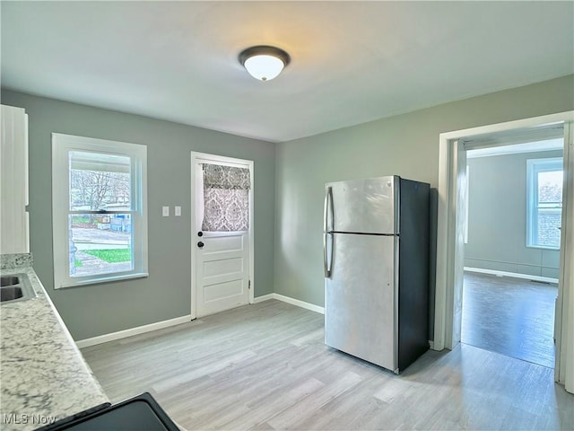 1341 Sharon Ave, Zanesville, OH 43701 - kitchen featuring light countertops, a sink, freestanding refrigerator, baseboards, and light wood-style floors