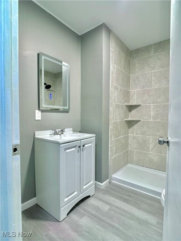 1341 Sharon Ave, Zanesville, OH 43701 - full bath featuring vanity, baseboards, a tile shower, and wood finished floors