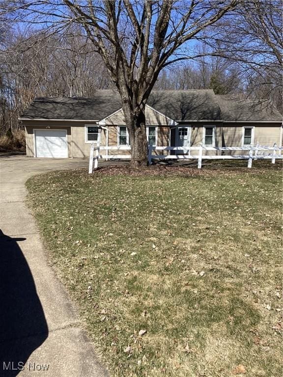 single story home with a garage, driveway, and a front lawn