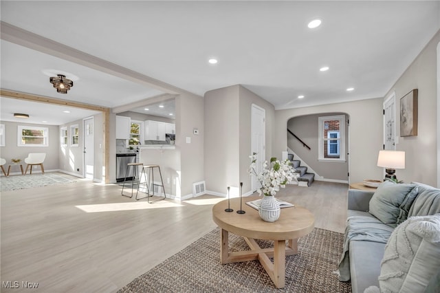 living room featuring recessed lighting, visible vents, plenty of natural light, and light wood-style floors