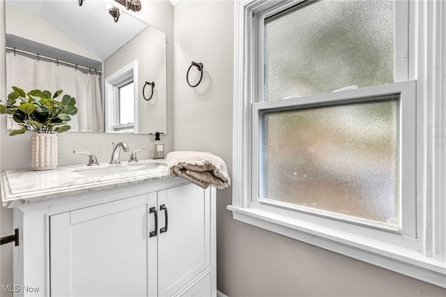 full bathroom featuring vanity and vaulted ceiling