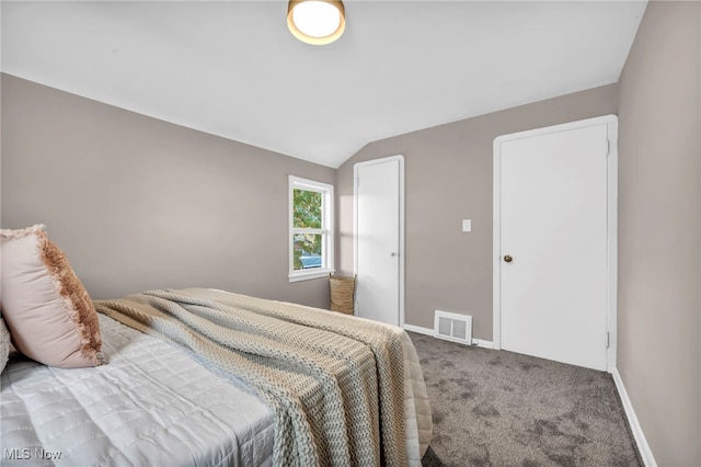 bedroom with baseboards, visible vents, carpet floors, and lofted ceiling