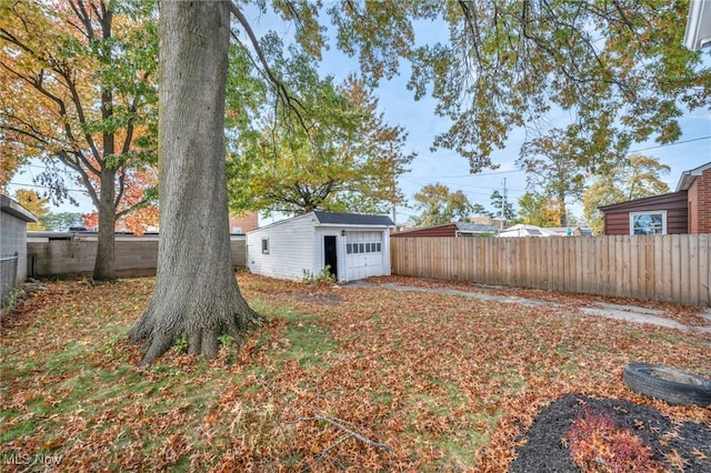 view of yard featuring an outbuilding, a storage unit, and a fenced backyard