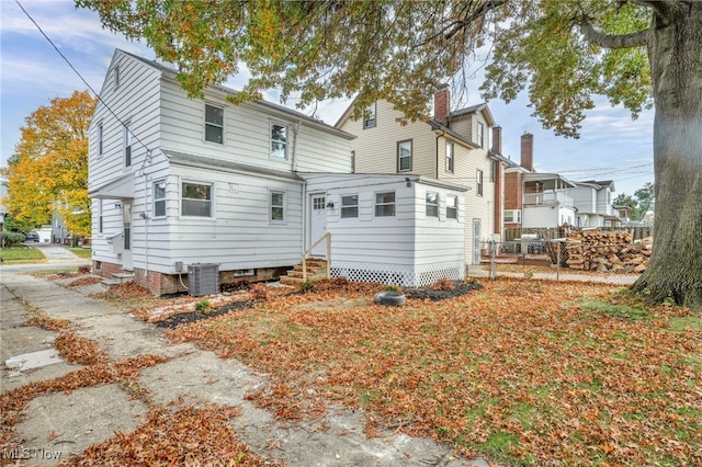 back of house featuring central air condition unit, fence, and entry steps