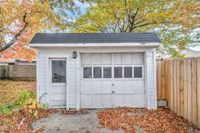 detached garage featuring fence