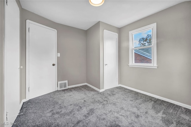 unfurnished bedroom with baseboards, visible vents, and carpet floors